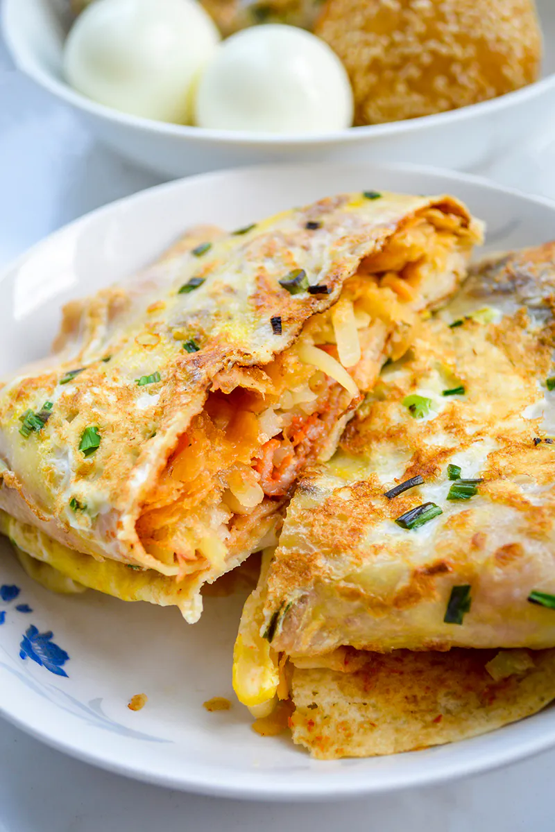 Folded egg pancake with shredded vegetable filling, garnished with chopped chives at Me + Crêpe, a Chinese Restaurant in Pasadena